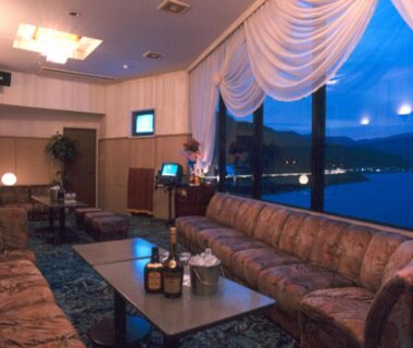 Lounge with patterned sofas and draped window, Hotel Sun Hatoya, Shizuoka