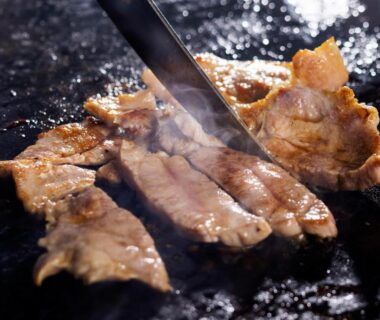 Sizzling sliced meat on a hotplate with spatula at Hotel Taikan in Iwate, Tōhoku, Japan