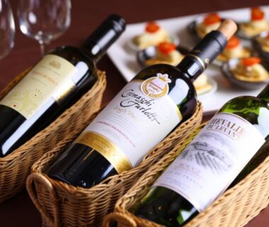 Three red wine bottles in woven baskets with hors d'oeuvres on a ryokan dining table