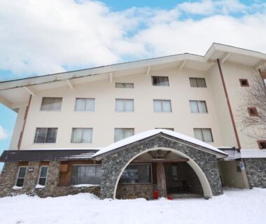 Exterior of Hotel Takimoto with snow-covered entrance arch and stone base in Nagano, Chūbu