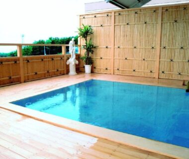 Outdoor pool with wooden deck and bamboo fence at Hotel Tetora Resort Tsuruoka, Yamagata