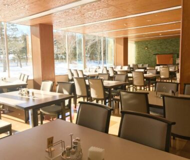 Spacious sunlit dining area with tables and chairs at Hotel Tetoraresort Tokachigawa, Hokkaidō, Japan