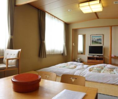 Traditional tatami room with futon bedding, low table and seating at Hotel Tetoraresort Tokachigawa, Hokkaidō