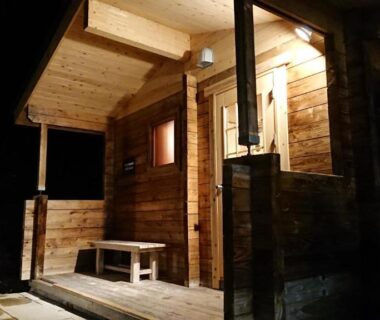 Nighttime wooden entrance with bench and warm lighting at Hotel Tetoraresort Tokachigawa in Hokkaidō