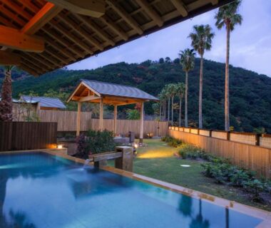 Outdoor onsen pool with wooden pergolas and mountain backdrop at Hotel Tokinoza, Mie, Kansai