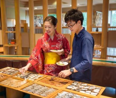 Guests wearing kimono selecting food from wooden trays at Hotel Tokinoza in Mie, Kansai