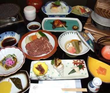 Assorted traditional dishes including grilled fish and beef served on lacquerware at Hotel Uguisu, Iwate