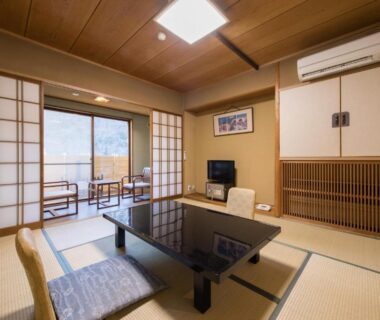Traditional tatami room with low table, shoji screens and balcony seating at Hotel Umenoyu in Nagano