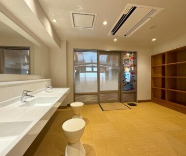 Long sink with stools and open wooden shelving in Hotel Uzuraya changing area, Nagano