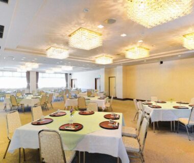 Bright banquet dining room with chandeliers and set tables at Hotel Wellness Notoji, Ishikawa, Chūbu