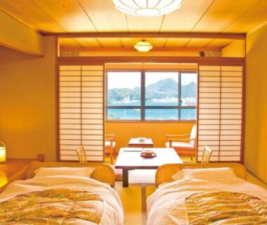 Tatami room with twin futons, shoji screens and low table at Hotel Yamadaya, Shizuoka