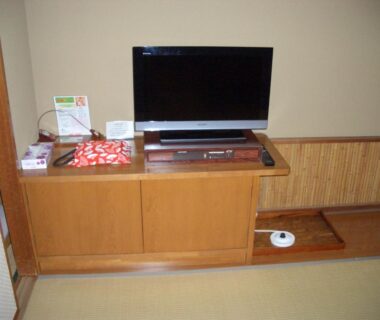 Flat-screen TV on low wooden cabinet in tatami room at Hotel Yamadaya, Shizuoka, Chūbu, Japan