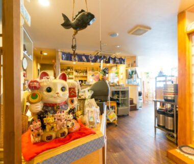Souvenir display with maneki-neko, shelves and shoji screen in Hotel Yudanaka lobby, Nagano