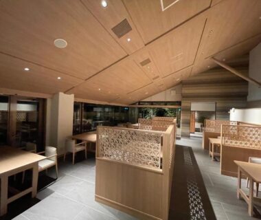 Minimal wooden dining room with partitioned booths and soft lighting at Hotel Yumeshizuku in Kumamoto, Kyūshū