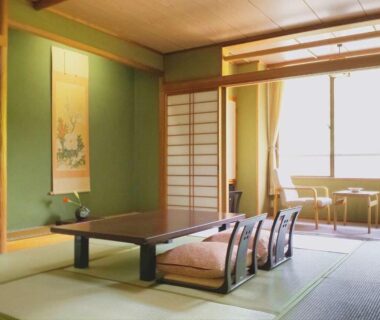 Traditional tatami room with low table, shoji screens and alcove at Hotel Yumoto Niigata