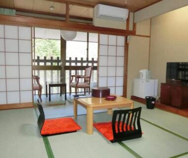 Traditional tatami room with low table, zabuton cushions and shoji screens at Hotel Yunishigawa, Tochigi