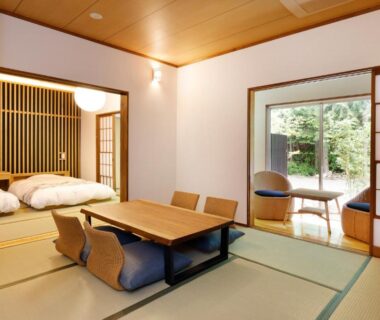 Tatami room with low table, futon and shoji doors at Hotel&Glamp YAMABOSHI, Nagano