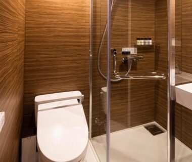 Compact modern bathroom with glass corner shower at Hotel&Glamp YAMABOSHI in Nagano Chūbu Japan