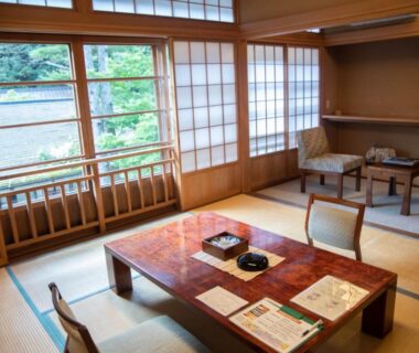 Tatami room with low lacquer table, shoji screens and garden view at Houshi Onsen Chojukan in Gunma