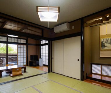 Spacious tatami room with low table, shoji screens, fusuma doors and hanging scroll at Hozanso Beppu in Ōita