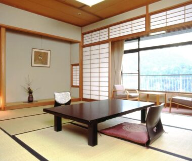 Traditional tatami room with low table, zabuton cushions, shoji screens and balcony overlooking wooded hills at Hyoe Koyokaku Hyōgo