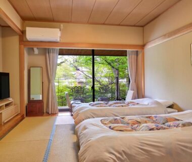 Tatami room with futons and garden view at IKOI Villa, Nagano