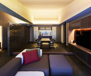Low-seated lounge with tatami flooring, wooden panels and ambient lighting at ITSUKUSHIMA IROHA, Hiroshima