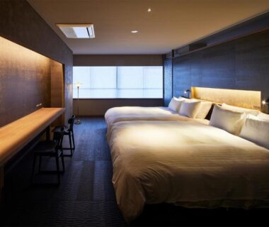 Minimalist twin bedroom with long wooden desk and translucent window screens at ITSUKUSHIMA IROHA, Hiroshima