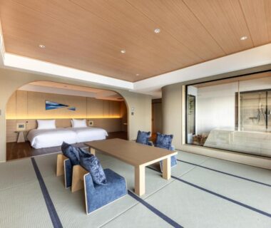 Tatami room with low table, floor chairs and bed at IZU RETREAT by Onko Chishin, Shizuoka
