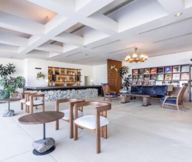 Spacious lounge with low wooden tables, seating, bookshelf and bar at IZU RETREAT by Onko Chishin in Shizuoka
