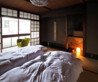 Tatami room with futons, shoji screens, window seat and small hearth in IZUYASU Traditional Kyoto Inn, Kyoto