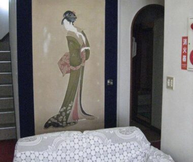 Low sofa in room with tall geisha wall panel, Ichifujiso ryokan in Yamanashi, Chūbu
