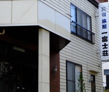 Entrance facade with vertical signboard and small balcony at Ichifujiso ryokan in Yamanashi