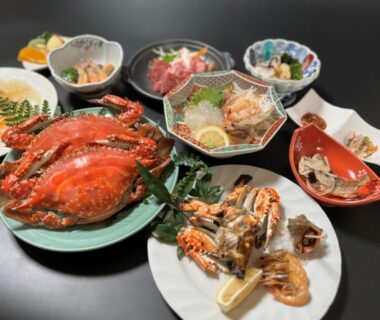 Assorted crab and seafood dishes with small bowls and garnishes on a dark lacquer table