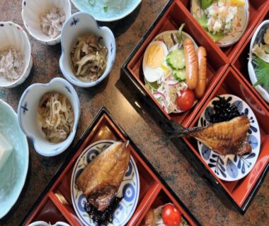 Assorted small dishes and bento trays with grilled fish, egg, tofu and pickles at Ichifukuso, Saga