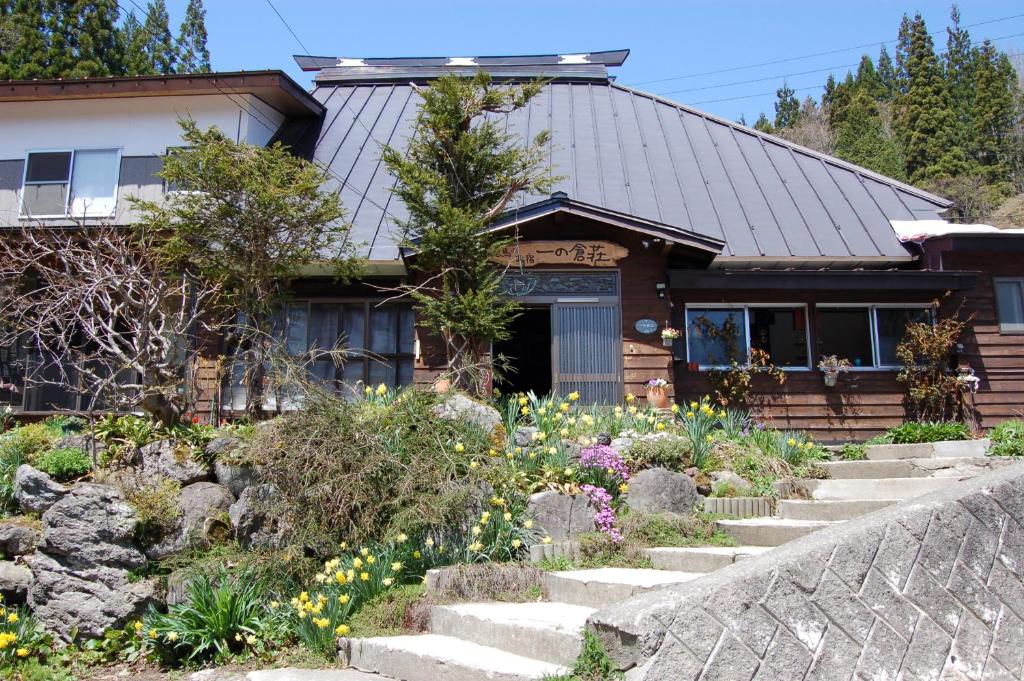 Wooden ryokan exterior with garden Ichinokurasou Nagano Wooden ryokan with stone steps and flower garden at Ichinokurasou in Nagano