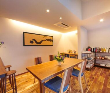 Wooden dining table and chairs with sideboard and artwork at Ichinomatsu Japanese Modern Hotel, Gifu