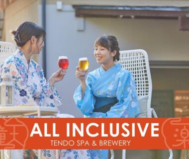 Two guests in yukata clinking glasses on a ryokan terrace at Ichiraku Tendo Spa in Yamagata