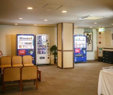 Lobby seating area with vending machines and columns at Ijika Daiichi Hotel Kagura Mie