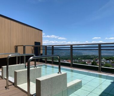 Rooftop tiled onsen baths with railing and mountain view at Ikaho Onsen Todoroki, Gunma, Japan