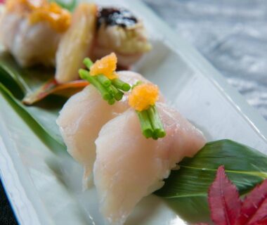 Assorted nigiri on ceramic plate with leaf garnish at Ikkoten, Ōita, Japan