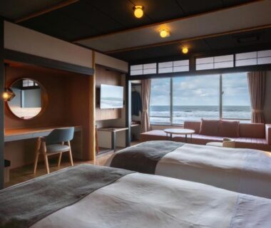 Twin beds and seating area facing sea at Ikkyu -Seaside Hotel- in Yamagata, Tōhoku