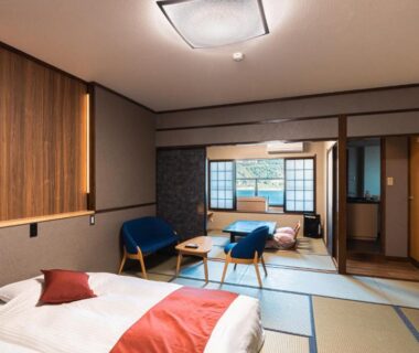Tatami-floored room with twin beds, low table and shoji screens at Inatori Akao Hotel Shizuoka
