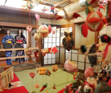 Two guests in yukata in tatami room with hanging fabric ornaments and shoji screens at Inatori Akao Hotel Shizuoka