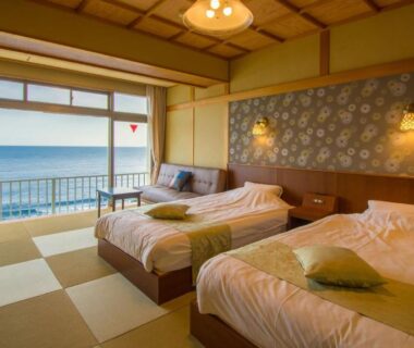 Twin beds on tatami floor with balcony overlooking the sea at Inatori Tokai Hotel Yuen, Shizuoka