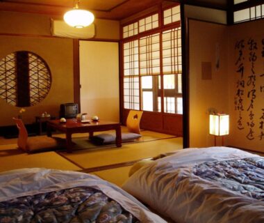Traditional tatami room with futons, low table, shoji screens and calligraphy scroll at Inn Kawashima in Kyoto
