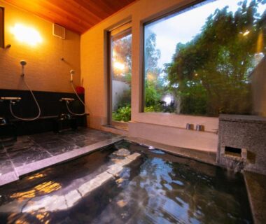 Indoor onsen with stone tub and garden view at Innter Hill Tsubasa Yufuin, Oita