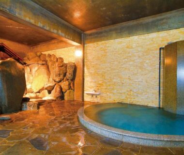 Circular indoor onsen with stone floor and rock wall at Irori Houraku, Hyōgo, Kansai