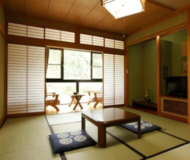 Traditional tatami room with low table, zabuton cushions and shoji screens at Irorino Yado Sankichi in Shizuoka