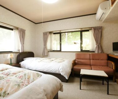 Bright twin bedroom with two beds, sofa and windows at Irorino Yado Sankichi in Shizuoka, Chubu
